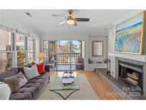 Inviting living room featuring a fireplace, plush sofa, and balcony with city views at 1101 E Morehead St, Charlotte, NC 28204
