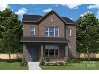 Charming two-story brick home with a covered front porch and lush landscaping at 17029 Malone Ln, Mint Hill, NC 28227