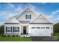 Inviting two-story home featuring a two-car garage, neutral siding, stone accents, and a well-manicured lawn at 1809 Ab Moore Jr Dr # 3238, Indian Trail, NC 28079