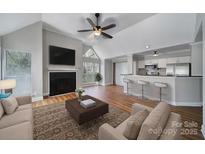 Bright living room featuring fireplace, vaulted ceiling, and breakfast bar with stainless steel appliances at 2500 Cranbrook Ln # 5, Charlotte, NC 28207