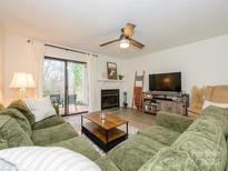 Inviting living room with a fireplace, sliding glass doors and plush green sectional sofa at 2900 Heathstead Pl # A, Charlotte, NC 28210
