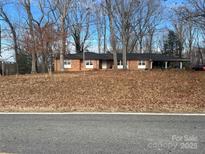 Charming brick ranch home featuring a covered carport and mature trees at 3367 Marshall Wolfe Rd, Kings Mountain, NC 28086