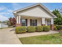 Charming home featuring a covered front porch and well-maintained landscaping with manicured shrubbery at 406 Llewellyn St, Belmont, NC 28012