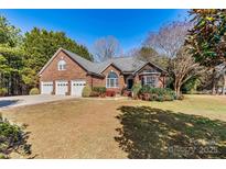 Charming brick home with three-car garage, manicured lawn, and mature landscaping at 4522 Long Cove Dr, Denver, NC 28037