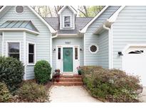 Charming home showcasing a quaint entrance, complemented by lush landscaping and a welcoming front door at 7007 Chapparall Ln, Charlotte, NC 28215