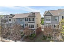 Charming townhome with blue accents, complemented by manicured landscaping and a welcoming front porch at 9330 Ainslie Downs St, Charlotte, NC 28273