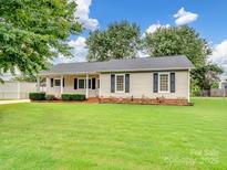 Charming single-story home with a well-manicured lawn, classic siding, and dark shutters at 12005 Charing Grove Ln, Charlotte, NC 28273