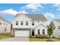 Charming two-story home with white siding, stone accents, a well-manicured lawn, and an attached two-car garage at 149 Saidin Ln, Troutman, NC 28166