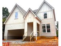 Striking new construction home with board and batten siding, covered entry, and attached two-car garage at 2530 Elkwood Cir, Charlotte, NC 28205