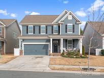 Charming two-story home with blue siding, black shutters, well-manicured lawn, and inviting front porch at 3038 Lydney Cir, Waxhaw, NC 28173