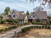 Beautiful brick home with a Tudor-style design, featuring a manicured lawn and a winding driveway at 418 3Rd Ne St, Hickory, NC 28601
