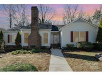 Charming single-story home features a brick chimney, red shutters, and a well-maintained front yard at 457 Birchwood Ne Trl, Concord, NC 28025