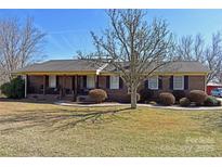 Charming one-story brick home with a covered front porch and mature landscaping at 4866 E Nc Hwy 150 Hwy, Lincolnton, NC 28092