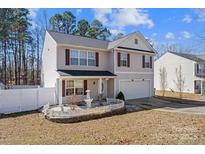 Charming home with manicured landscaping, white picket fencing, and a two-car garage at 10816 Pointer Ridge Dr, Charlotte, NC 28214