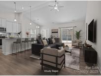 Bright, open-concept living room boasts modern furnishings and a seamless flow to the outdoor patio at 127 Tradesmen Trl, Troutman, NC 28166