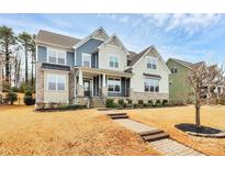 Charming two-story home boasts manicured lawn, stone accents, and a welcoming front porch at 14125 Derby Farm Ln, Charlotte, NC 28278