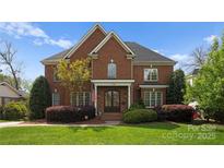 Stately brick home featuring a manicured lawn and lush landscaping at 1754 Sterling Rd, Charlotte, NC 28209