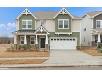 Two-story home with attached two-car garage, stone accents, and a combination of siding and shake exterior at 2034 Puddle Pond Rd # Lot 563, Indian Trail, NC 28079