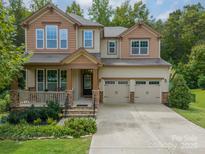 Charming two-story home with a welcoming front porch and a two-car garage at 2108 Clarion Dr, Fort Mill, SC 29707