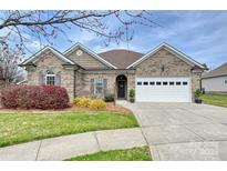 Charming brick home with a manicured lawn, tidy landscaping and a two-car garage at 258 Lagoda Dr, Locust, NC 28097