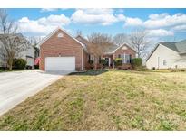 Charming brick home featuring a two-car garage and well-manicured lawn at 3851 Yellow Jasmine Dr, Gastonia, NC 28056
