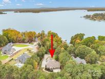Stunning lakefront home featuring lush trees and private boat dock, offering scenic waterfront living at 472 Barber Loop, Mooresville, NC 28117