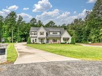 Charming two-story modern farmhouse with a beautifully landscaped front yard and inviting front porch at 5941 Legacy Ln, Kannapolis, NC 28081