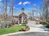 Stately brick home features a manicured lawn, mature trees, and an attached two-car garage at 726 Amberly Xing, Fort Mill, SC 29708