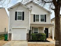 Charming two-story home featuring stone accents, an attached one-car garage, and a cozy front porch at 7306 Fox Point Dr, Charlotte, NC 28269