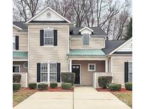 Charming townhome featuring black shutters, well-maintained landscaping, and a cozy covered entryway at 1765 Holliford Ct, Charlotte, NC 28215