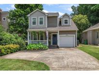 Charming two-story home with a covered porch, attached garage, and a well-manicured front yard at 1921 Kenilworth Ave, Charlotte, NC 28203