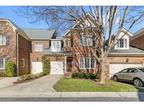 Charming brick townhome with a well-manicured lawn and attached garage at 243 Crownsgate Ct, Charlotte, NC 28207