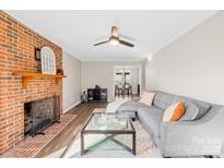 Comfortable living room with brick fireplace, hardwood floors, and views into the dining area at 2927 Forest Hills Cir, Rock Hill, SC 29732