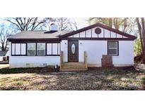 Charming exterior of a white brick home featuring updated paint and a black trim package at 506 E Ridge St, Kings Mountain, NC 28086