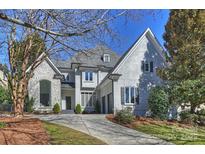 Stunning two-story home with a stone facade, stucco, manicured lawn, and driveway leading to a two car garage at 5225 Lila Wood Cir, Charlotte, NC 28209