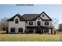 Beautiful two-story home featuring a large front yard and eye-catching black and white trim at 11016 Tyler Brook Ln # Oak0036, Mint Hill, NC 28227
