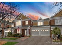 Beautiful brick townhome showcasing an attached two car garage and covered porch, offering curb appeal at 18409 Harborside Dr, Cornelius, NC 28031
