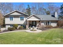 Charming home featuring a manicured lawn, inviting front porch, and beautiful water fountain centerpiece at 19320 Davidson Concord Rd, Davidson, NC 28036
