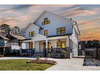 Charming two-story white home with a welcoming front porch and well-manicured lawn at 2526 Fort St, Charlotte, NC 28205