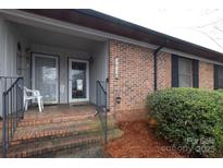 Inviting brick front porch with dual doors and black railing, enhancing curb appeal at 281 S Herlong Ave # Apt E, Rock Hill, SC 29732