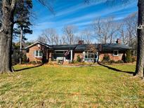 Charming brick home featuring a well-maintained lawn and beautiful mature trees at 505 Tuttlewood Dr, Kannapolis, NC 28083