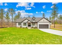 Beautiful single-Gathering home with a lush green lawn and well-manicured landscaping at 5147 Star Magnolia Ct, Clover, SC 29710