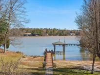 Scenic waterfront view showcasing a private dock with a charming gazebo, surrounded by serene water and lush landscapes at 5981 Johnson Rd, Lake Wylie, SC 29710
