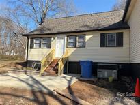 View of the side of the house showing the siding, windows with shutters, door and steps at 622 Watts St, Albemarle, NC 28001