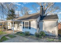 Quaint single-story home showcasing the side yard, chimney, and covered front porch at 800 Woodlawn St, Belmont, NC 28012