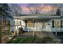 Charming single-story home with a covered porch, wood fence, and tidy landscaping at 800 Woodlawn St, Belmont, NC 28012