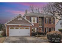 Charming brick home featuring an attached garage, manicured landscaping, and a welcoming entrance at 8433 Delberry Ln, Charlotte, NC 28277