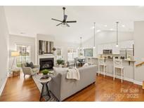 Bright, open living room featuring a fireplace, hardwood floors, and a seamless flow to the modern kitchen at 1055 Curry Way, Matthews, NC 28104