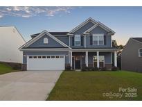 Charming two-story home with blue siding, white trim, and well-maintained landscaping at 111 Megby Trl, Statesville, NC 28677