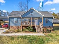 Charming single-Gathering home featuring a quaint front porch, light blue siding and a well-manicured lawn at 131 Lowry Row # 8, York, SC 29745